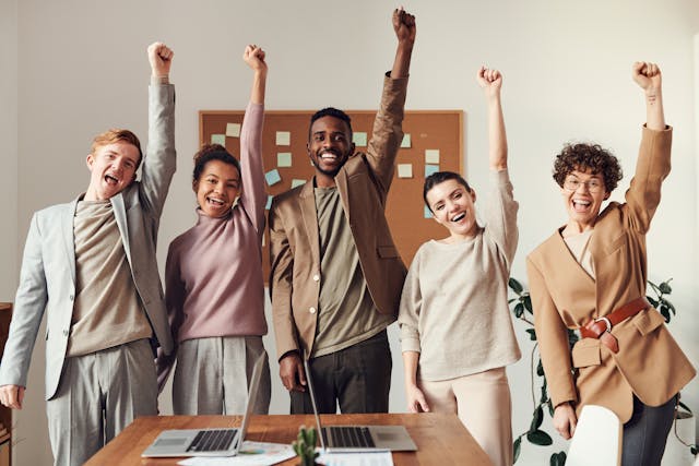 Five happy employees representing the positive impact of employee benefits Toronto, provided by Eternal Safety Insurance