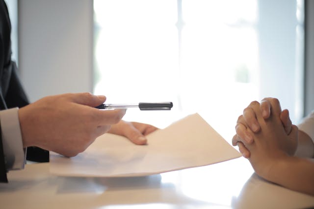 Person signing a contract, symbolizing the commitment to a term life insurance policy in Toronto.